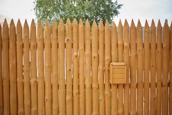 Ogrodzenie Wykonane Jest Drewnianych Desek Formie Palisady Wisi Nim Skrzynka — Zdjęcie stockowe