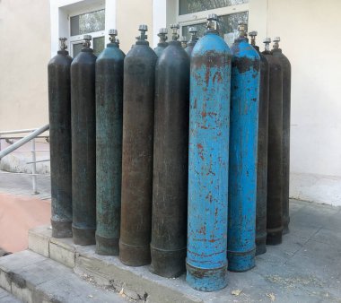 Hastanenin verandasında hastalar için bir sürü oksijen tüpü var..