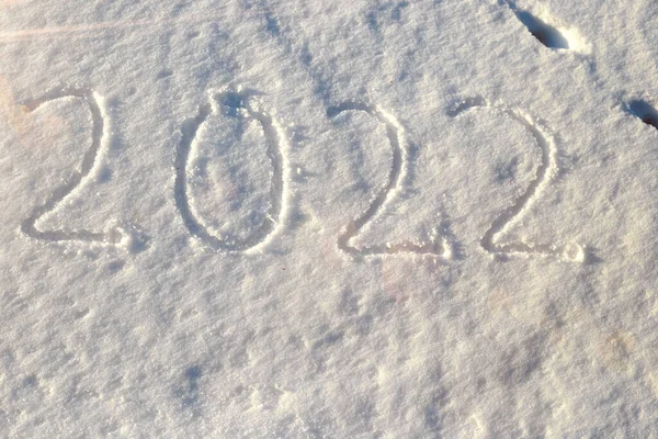 Os números 2022 estão escritos na neve para a chegada do Natal e a celebração do novo ano — Fotografia de Stock