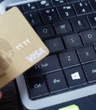 Fotoğrafta, klavyenin arka planında plastik bir vize var, online ödeme kavramı..