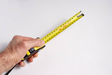 Metre ölçüm cihazının beyaz arka planında, inşaat onarım konsepti.