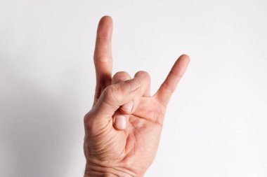 El beyaz arkaplanda, iki parmak işaret parmağı ve serçe parmak görünüyor..