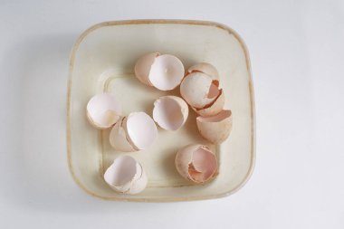 Beyaz bir masada, bir fincanda kirli yumurta kabuğu..