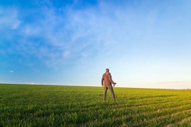 Sahada gün batımı, sahada ayakta duran bir adam gün batımıyla karşılaşır.