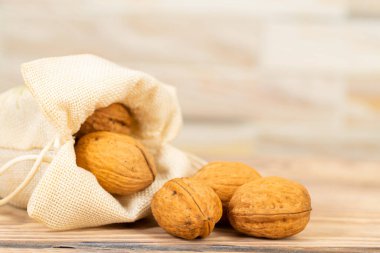 Masadaki keten poşetten dökülen cevizler.