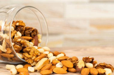 Farklı fındık karışımı cam bir kavanozdan masaya dökülür. Doku ve arka plan olarak fındık, makro