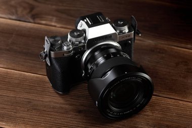 Minsk, Belarus - 16 Ekim 2021 FUJIFILM X-T4 KIT XF16-80MM SILVER kamera gövdesi kahverengi ahşap zemin üzerinde.