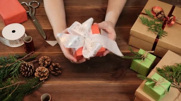 Rotes Weihnachtsgeschenk Mit Einer Weißen Schleife Schneeflocken Frauenhänden Geschenkverpackung Weihnachten — Stockvideo
