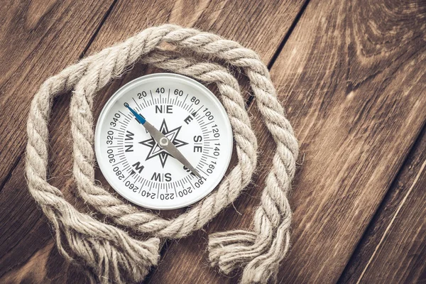 Kompass und Seil auf Holz Textur Hintergrund — Stockfoto