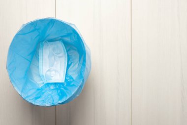 Çöp kutusunda kullanılan hijyenik maske, bulaşıcı atık, virüsün bulaşan atığı ayırarak covid-19 'u engellemiş. Arkaplanda karantina var. Yüz maskesi kullanımı. Tek kullanımlık yüz maskesi kullanımı.