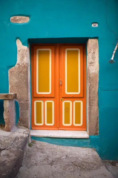 Puerta delantera pintada de manera brillante en el colorido casco antiguo de Bosa, Cerdeña, Italia — Foto de Stock