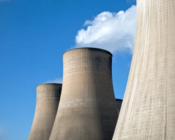 Kühltürme eines Kohlekraftwerks vor blauem Himmel lizenzfreie Stockbilder