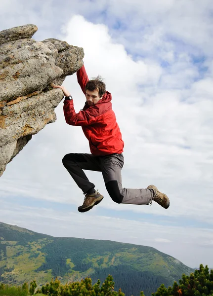 Jonge man klimmen op een klif — Stockfoto