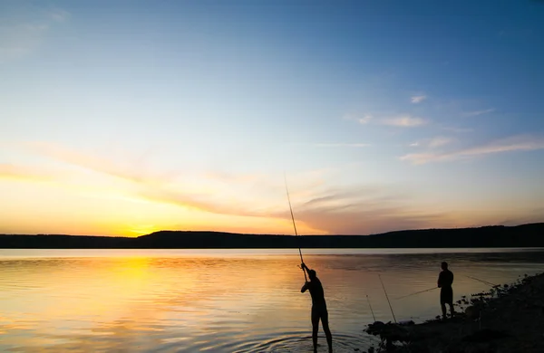 Silhuett av två fiskare vid solnedgången — Stockfoto