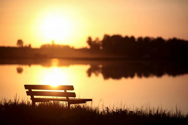 城市公园湖边的长椅 夕阳西下 背景模糊 秋天公园长椅上的风景 — 图库照片#