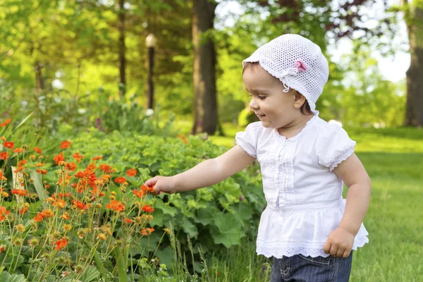 Küçük kız çiçekleri ile oynama — Stok fotoğraf