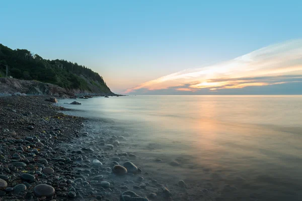 Brzeg oceanu w bladym świtem (prędkość migawki) — Zdjęcie stockowe