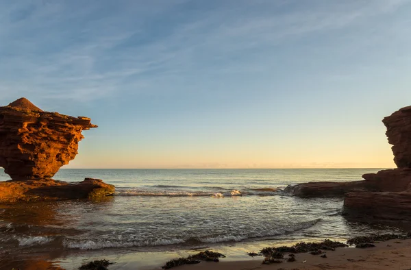 Red sandstone rocks at high tide — Stock Photo, Image