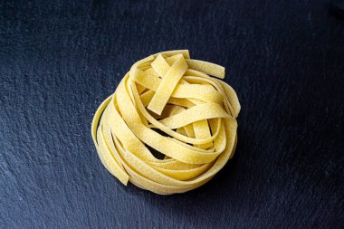 Dry Italian tagliatelle pasta background healthy food photo Top view Close-up