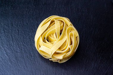 Dry Italian tagliatelle pasta background healthy food photo Top view Close-up