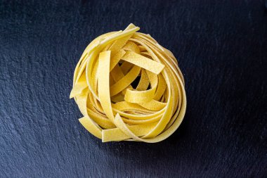 Dry Italian tagliatelle pasta background healthy food photo Top view Close-up