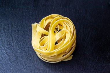 Dry Italian tagliatelle pasta background healthy food photo Top view Close-up