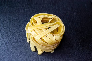 Dry Italian tagliatelle pasta background healthy food photo Top view Close-up