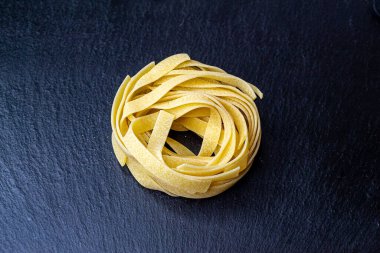 Dry Italian tagliatelle pasta background healthy food photo Top view Close-up