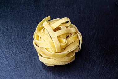 Dry Italian tagliatelle pasta background healthy food photo Top view Close-up