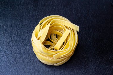 Dry Italian tagliatelle pasta background healthy food photo Top view Close-up