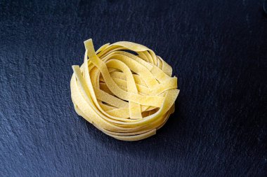 Dry Italian tagliatelle pasta background healthy food photo Top view Close-up