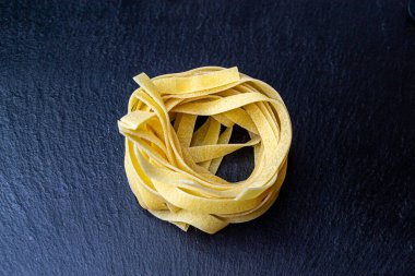 Dry Italian tagliatelle pasta background healthy food photo Top view Close-up