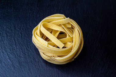Dry Italian tagliatelle pasta background healthy food photo Top view Close-up