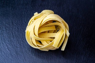 Dry Italian tagliatelle pasta background healthy food photo Top view Close-up