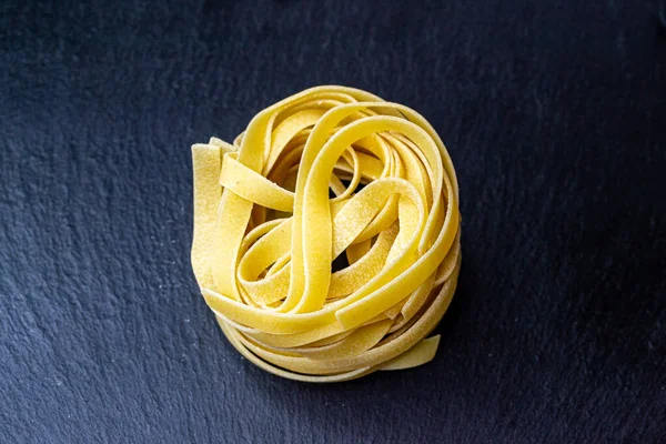 Dry Italian tagliatelle pasta background healthy food photo Top view Close-up
