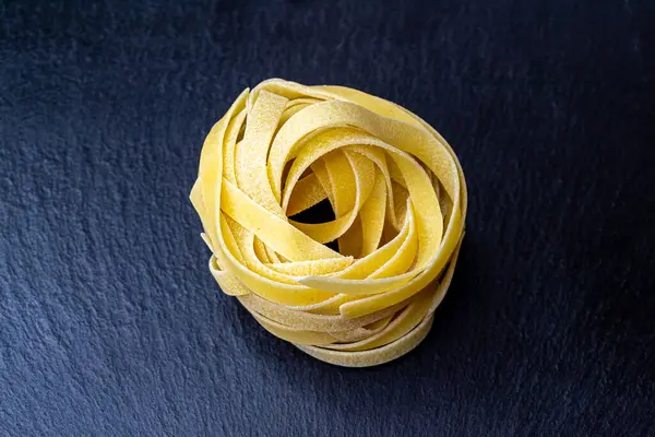 Dry Italian tagliatelle pasta background healthy food photo Top view Close-up