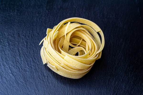 Dry Italian tagliatelle pasta background healthy food photo Top view Close-up