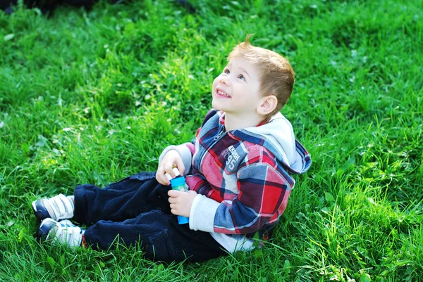 Beautiful child on the green grass — Stock Photo, Image