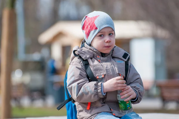 Beautiful boy drinking water from a bottle — Stock Photo, Image