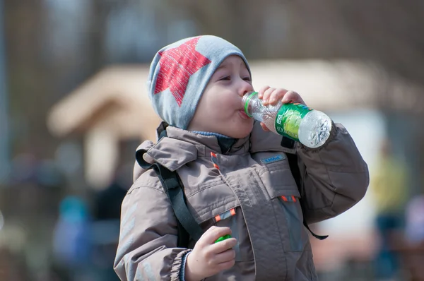 Beautiful boy drinking water from a bottle — Stock Photo, Image