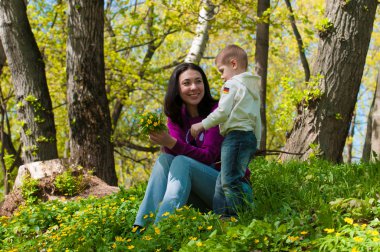 Anne ve oğlu, güneşli bir çim üzerinde oynamak