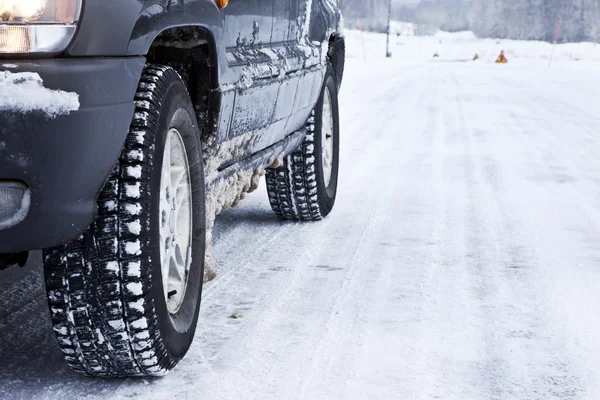 Samochód na drodze snowy lasu — Zdjęcie stockowe