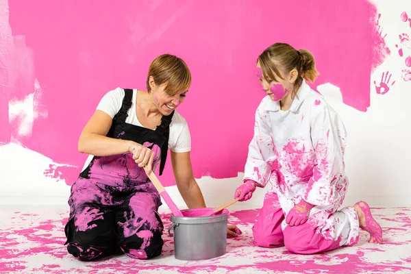 Madre Hija Revolviendo Cubo Pintura Con Palos Madera Color Rosa Imagen De Stock