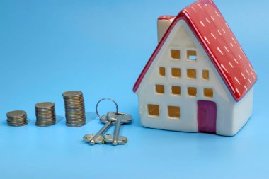 Anahtarı ve parası olan ev modeli. İnşaat, borç alma, gayrimenkul, ev değeri veya yeni bir ev satın alma..