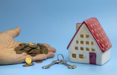 Küçük ev, bozuk para ve anahtar yığını, ipotek konsepti.