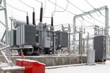 Kışın yüksek voltajlı elektrik santralinde güç transformatörü..