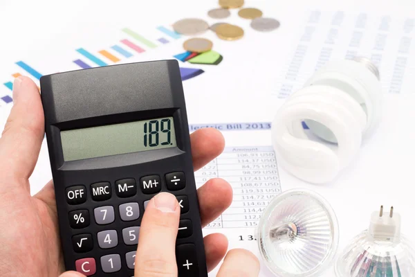 Light bulb, calculator and euro coins — Stock Photo, Image