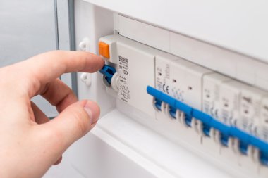 Man turning on the fuse box clipart