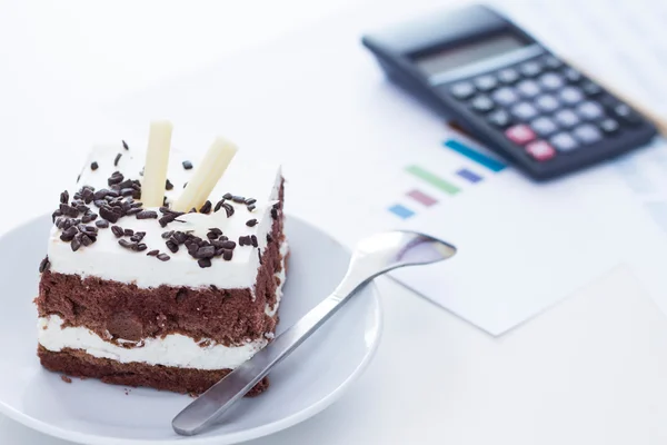 Zeit für etwas Süßes. Biskuitkuchen mit Schokolade auf dem Schreibtisch — Stockfoto