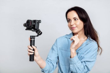 Genç ve çekici bir kadın fotoğraf makinesi kullanarak fotoğraf çekiyor.